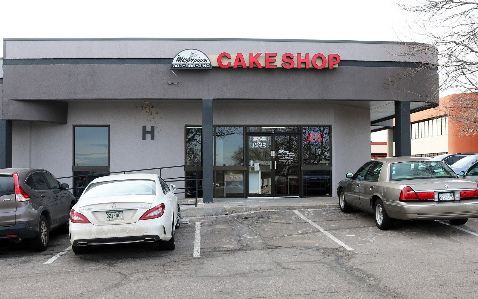 Cars parked outside the Masterpiece Cakeshop storefront in a strip mall