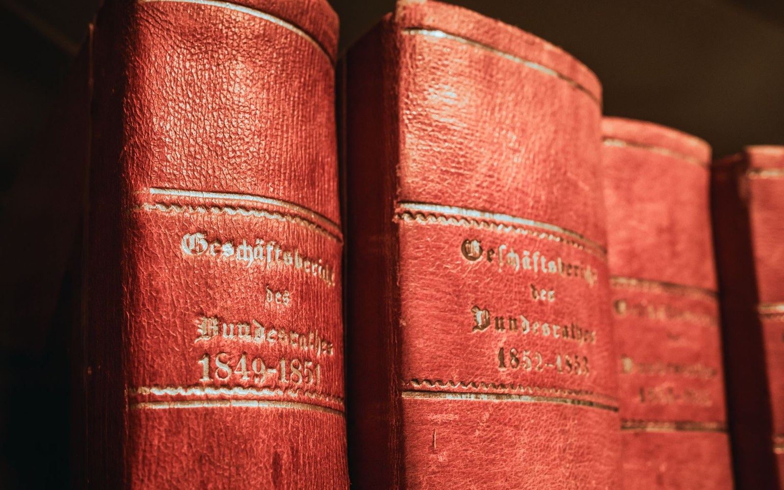 A run of bound United States Reports volumes open on a reading table, spine labels visible, an adult researcher's hands visible at the edge of the frame